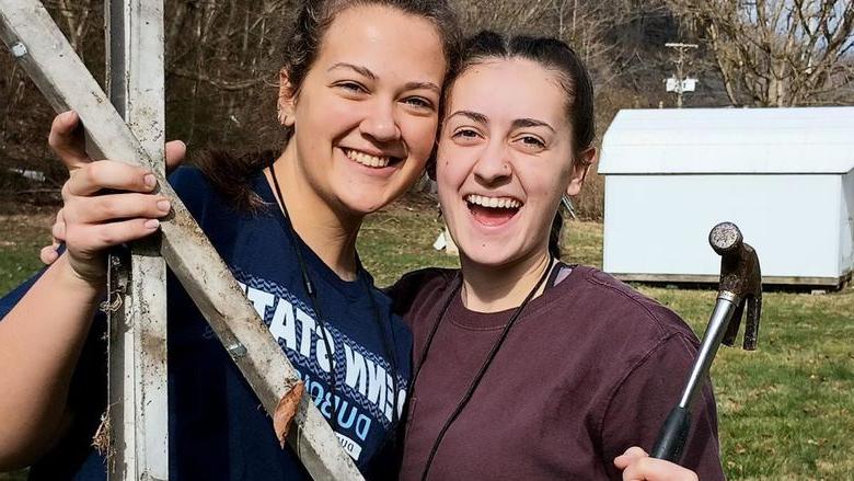 Penn State DuBois students Tayler Rafferty, left, and Hannah Thompson, right, 作为365英国上市杜波依斯分校基督教学生团契的一部分，他们在肯塔基州的服务之旅中停下来拍了张照片.