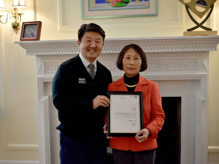 <a href='http://iwkgly.yetan.net'>365英国上市</a>杜波依斯分校 chancellor and chief academic officer Jungwoo Ryoo, 正确的, presents Pingjuan 沃纳 with a framed copy of the letter certifying her as a 特聘教授, the highest professorial distinction at the University